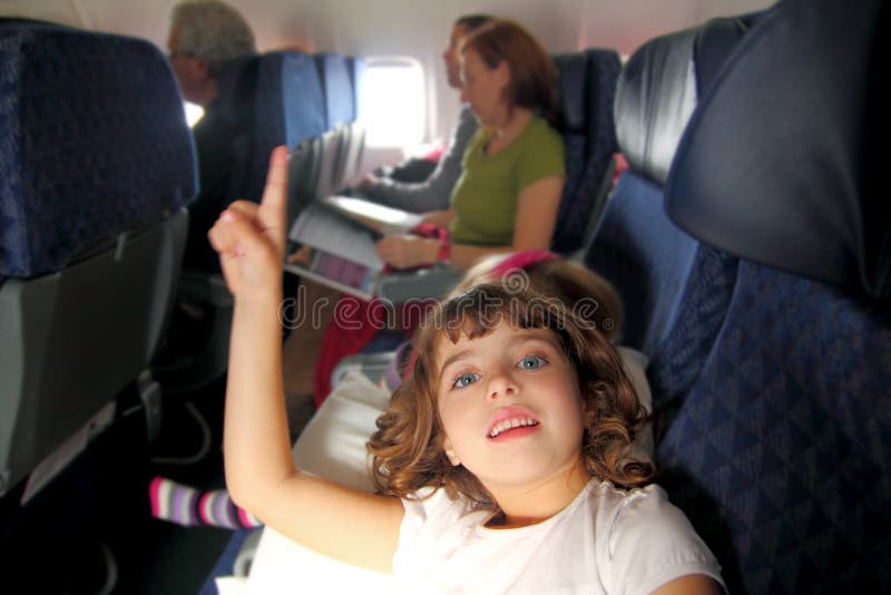 Little girl inside aircraft rising up finger smiling. Little girl inside aircraft rising up finger smiling