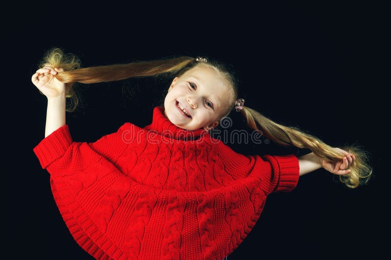 Niña divertida en suéter rojo foto de archivo Niña divertida en suéter rojo foto de archivo