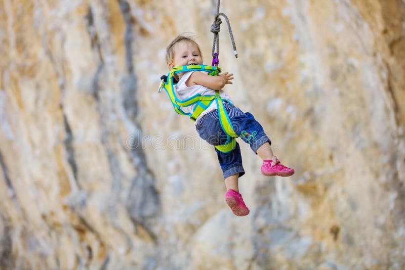 Niña en la ejecución del engranaje del climbng en cuerda fotografía de archivo libre de regalías Niña en la ejecución del engranaje del climbng en cuerda fotografía de archivo libre de regalías