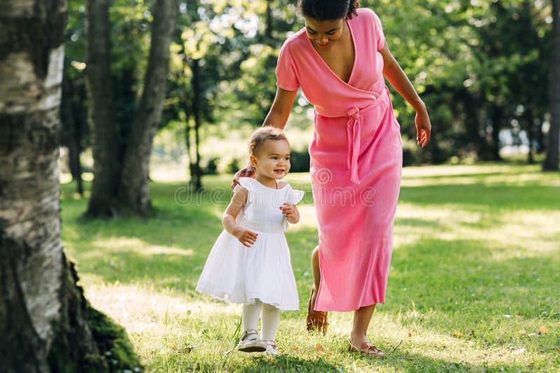 Niña feliz caminando por el césped en un parque fotos de archivo libres de regalías