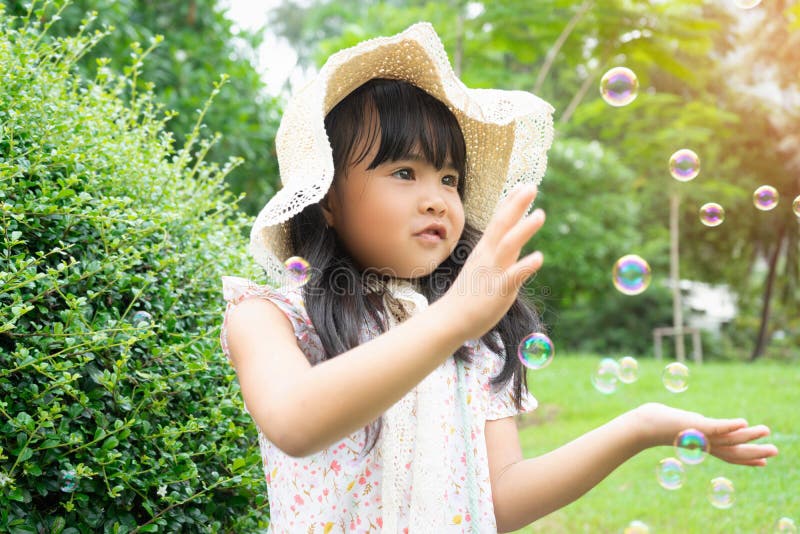 Niña feliz jugar con burbujas de jabón foto de archivo