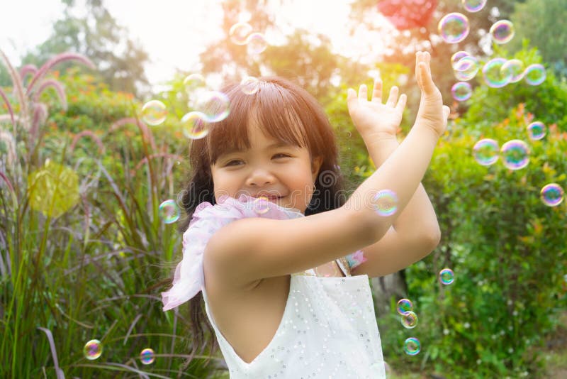 Niña feliz jugar con burbujas de jabón imagen de archivo libre de regalías