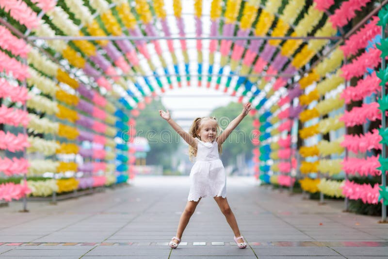 Niña feliz que salta y que se divierte en el callejón soleado brillante borroso del parque Concepto descuidado feliz de la ni?ez foto de archivo libre de regalías Niña feliz que salta y que se divierte en el callejón soleado brillante borroso del parque Concepto descuidado feliz de la ni?ez foto de archivo libre de regalías