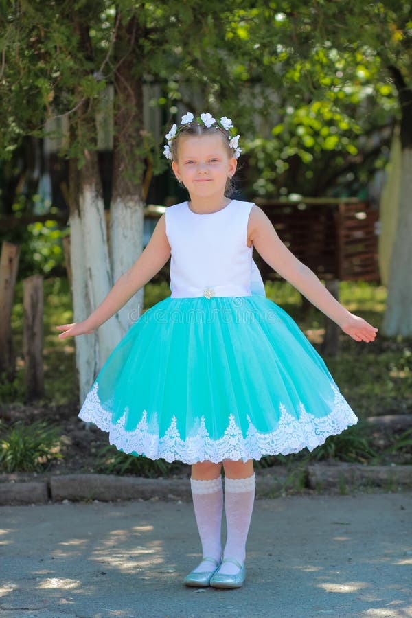 niña hermosa en el vestido que se coloca y que presenta sobre el fondo de la naturaleza, niño con una guirnalda de flores artific imágenes de archivo libres de regalías niña hermosa en el vestido que se coloca y que presenta sobre el fondo de la naturaleza, niño con una guirnalda de flores artific imágenes de archivo libres de regalías