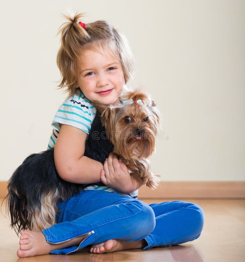 Niña linda con el terrier de Yorkshire interior foto de archivo libre de regalías Niña linda con el terrier de Yorkshire interior foto de archivo libre de regalías