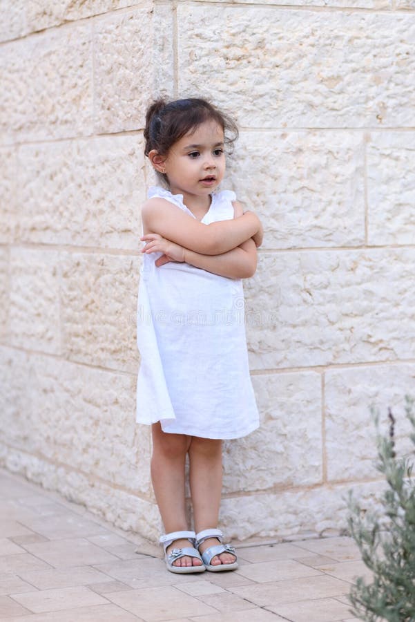 Niña linda con la presentación blanca del vestido al aire libre ?rbol en campo foto de archivo Niña linda con la presentación blanca del vestido al aire libre ?rbol en campo foto de archivo