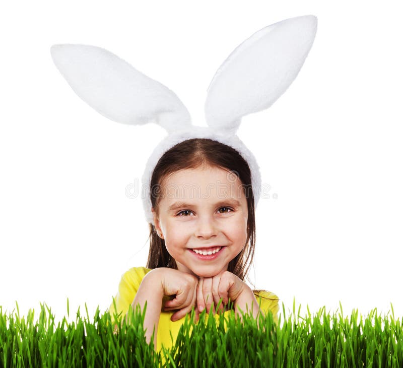 Niña linda en un traje del conejo, una hierba verde fresca en un fondo blanco foto de archivo Niña linda en un traje del conejo, una hierba verde fresca en un fondo blanco foto de archivo