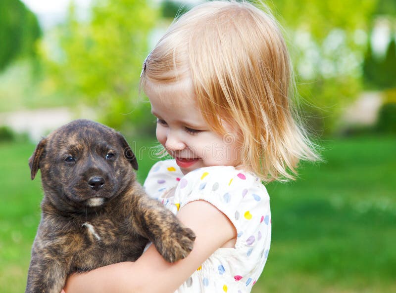 Niña linda que abraza el perrito del perro imagen de archivo Niña linda que abraza el perrito del perro imagen de archivo