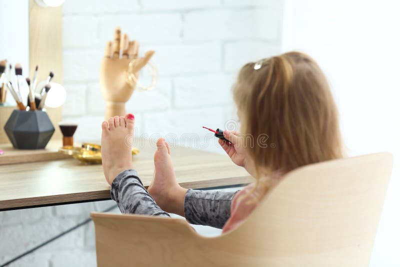 Niña linda que pinta sus clavos imagen de archivo Niña linda que pinta sus clavos imagen de archivo