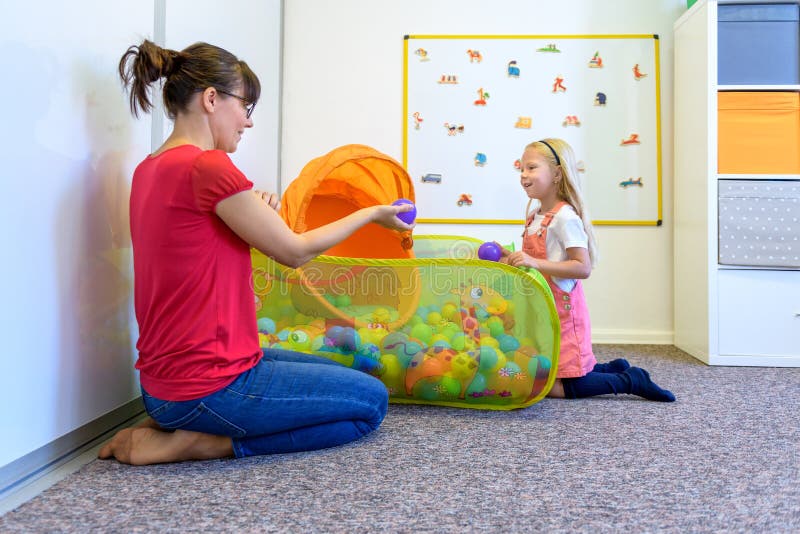 Niña pequeña en sesión de terapia ocupacional infantil haciendo ejercicios juguetones con su terapeuta