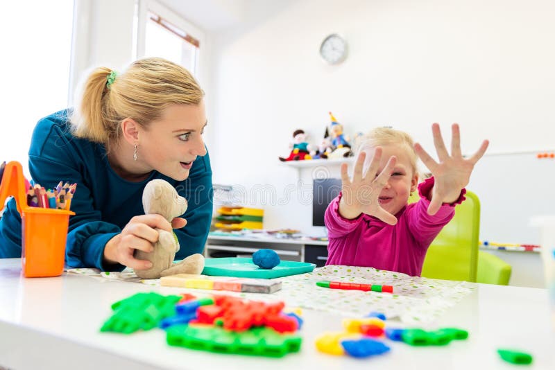 NiÃ±a pequeÃ±a en sesiÃ³n de terapia ocupacional infantil haciendo ejercicios sensoriales de juego con su terapeuta