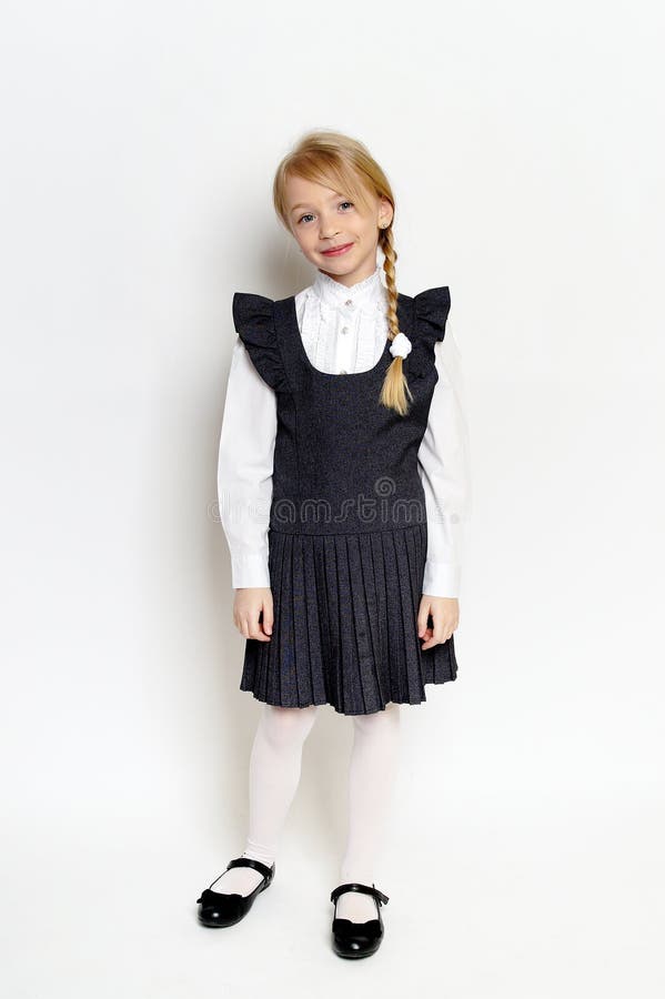 Niña pequeña posando con uniforme escolar foto de archivo