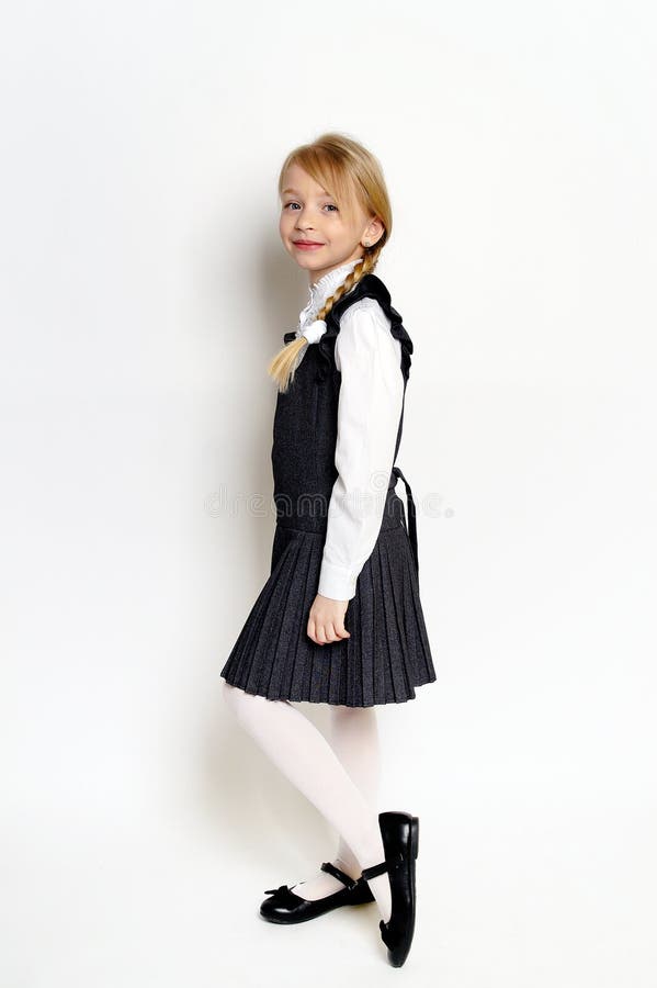 Niña pequeña posando con uniforme escolar foto de archivo