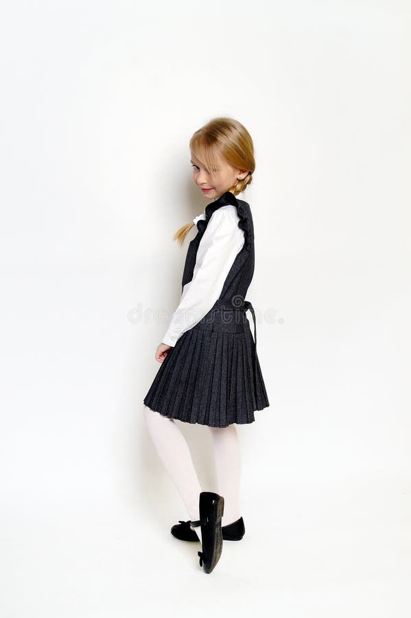 Niña pequeña posando con uniforme escolar fotografía de archivo