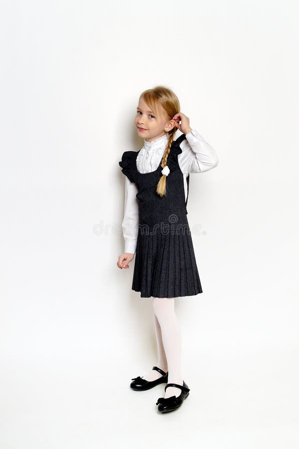 Niña pequeña posando con uniforme escolar imágenes de archivo libres de regalías