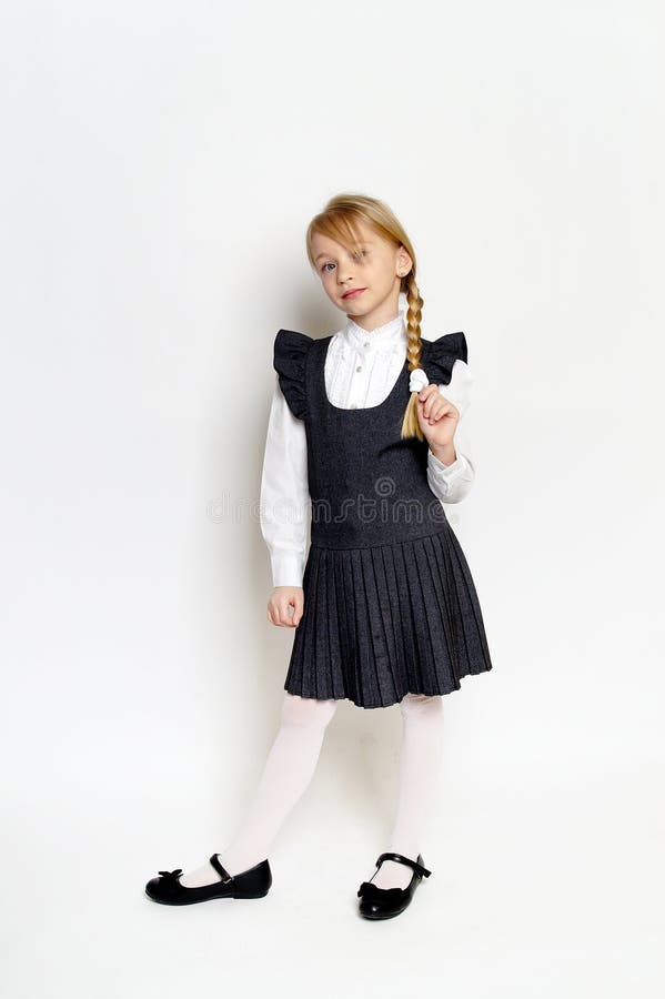 Niña pequeña posando con uniforme escolar fotografía de archivo