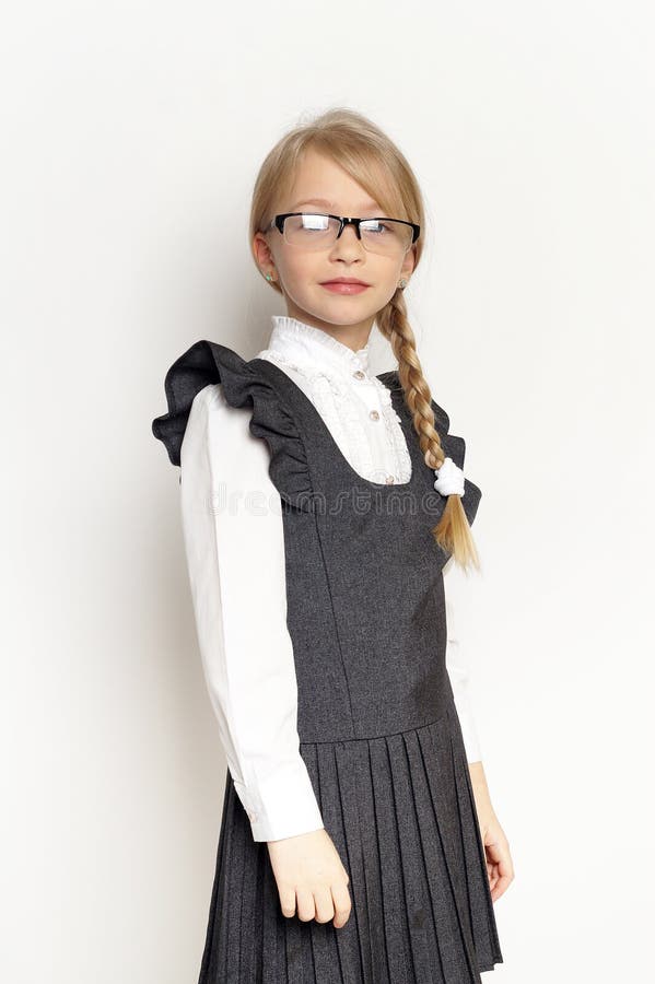 Niña pequeña posando con uniforme escolar fotografía de archivo
