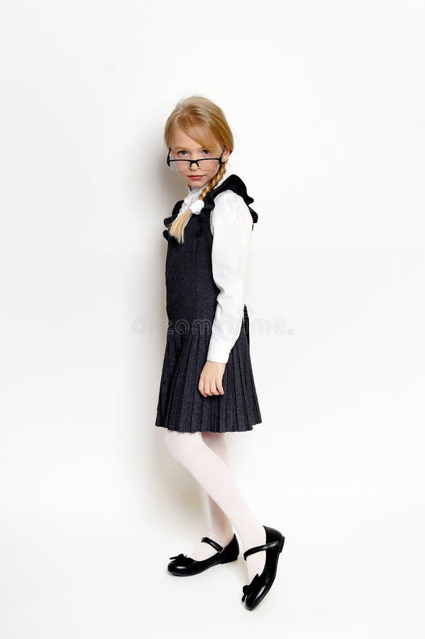 Niña pequeña posando con uniforme escolar imagen de archivo libre de regalías