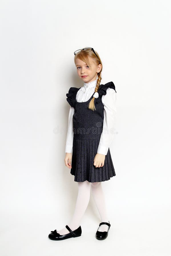 Niña pequeña posando con uniforme escolar imágenes de archivo libres de regalías