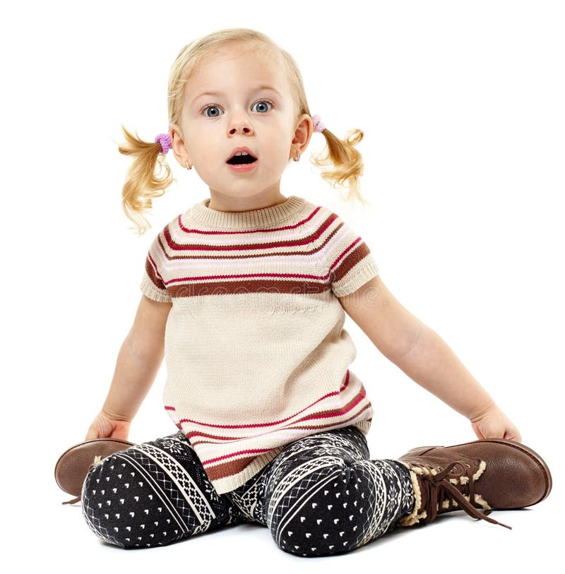 Niña pequeña que se sienta en el piso y que expresa sorpresa foto de archivo libre de regalías Niña pequeña que se sienta en el piso y que expresa sorpresa foto de archivo libre de regalías