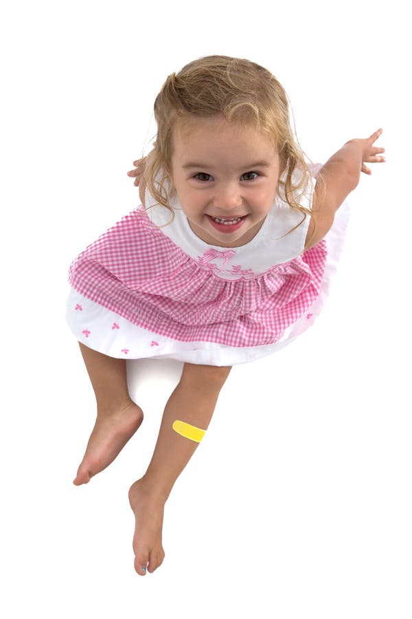 Niña pequeña que sonríe en su vestido rosado imagen de archivo Niña pequeña que sonríe en su vestido rosado imagen de archivo