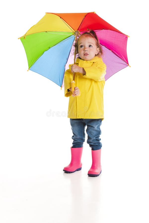 Niña pequeña sosteniendo el paraguas color revisando la lluvia aislada en blanco foto de archivo