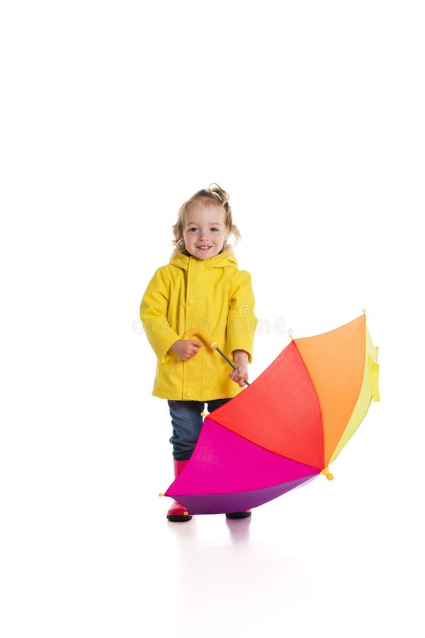 Niña pequeña sosteniendo el paraguas color revisando la lluvia aislada en blanco foto de archivo libre de regalías