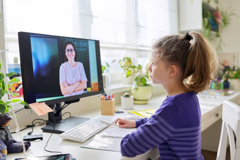Niña preadolescente que estudia en casa usando una lección de video en computadora foto de archivo libre de regalías