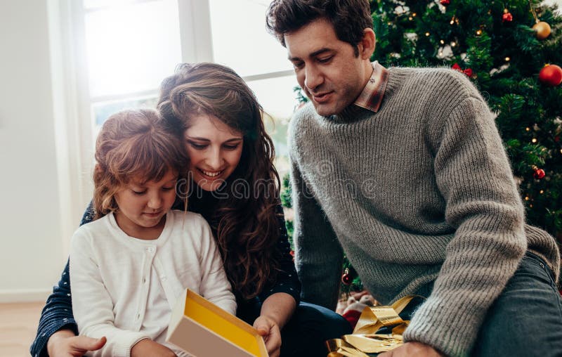 Niña que abre su regalo de Navidad foto de archivo libre de regalías Niña que abre su regalo de Navidad foto de archivo libre de regalías