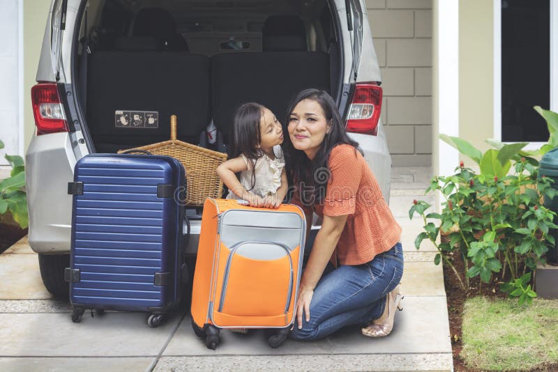 Niña que besa a su madre cerca de un coche imagen de archivo libre de regalías Niña que besa a su madre cerca de un coche imagen de archivo libre de regalías