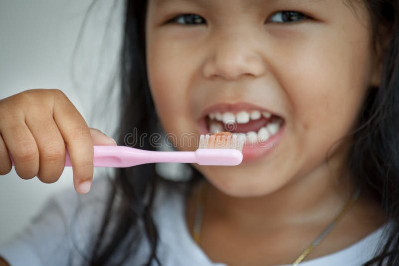 Niña que cepilla sus dientes cerca para arriba en el cepillo de dientes foto de archivo libre de regalías Niña que cepilla sus dientes cerca para arriba en el cepillo de dientes foto de archivo libre de regalías