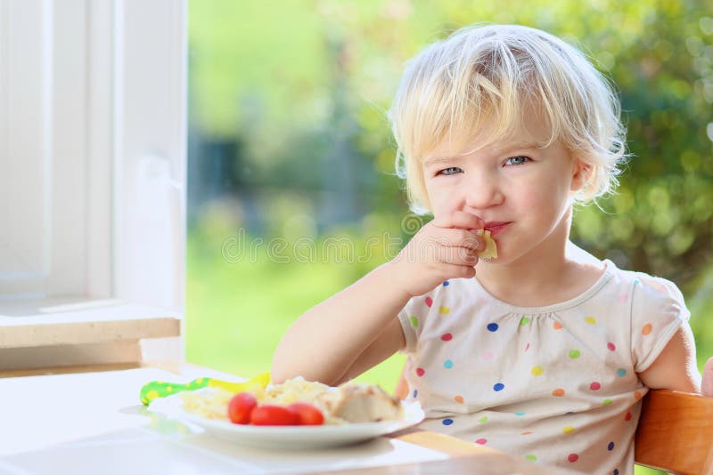 Niña que come las pastas para el almuerzo imagen de archivo libre de regalías Niña que come las pastas para el almuerzo imagen de archivo libre de regalías