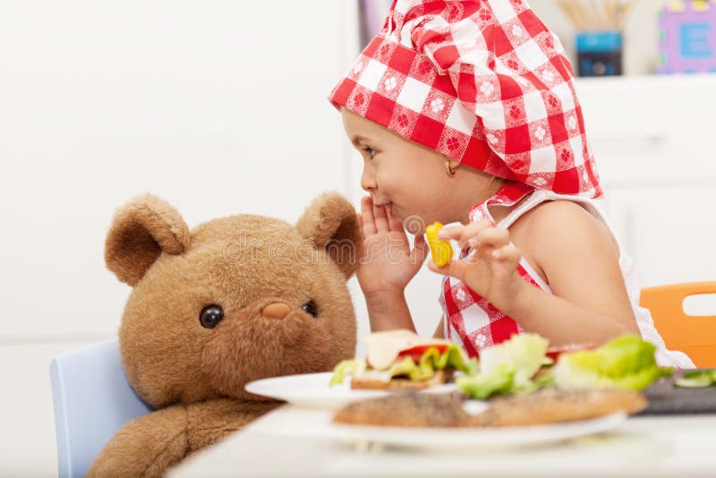 Niña que comparte secretos con su oso de peluche foto de archivo libre de regalías Niña que comparte secretos con su oso de peluche foto de archivo libre de regalías