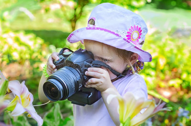Niña que fotografía las flores imagenes de archivo Niña que fotografía las flores imagenes de archivo