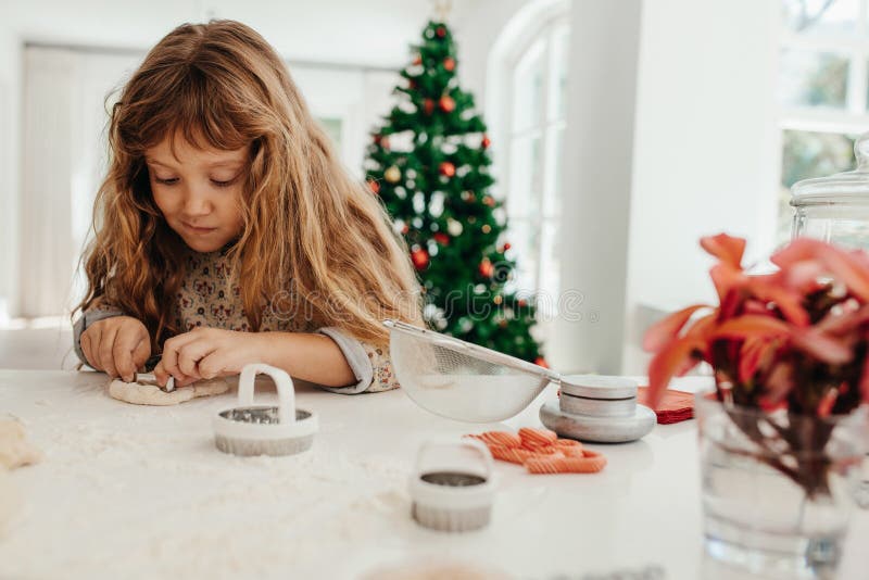 Niña que hace las galletas para la Navidad foto de archivo libre de regalías Niña que hace las galletas para la Navidad foto de archivo libre de regalías