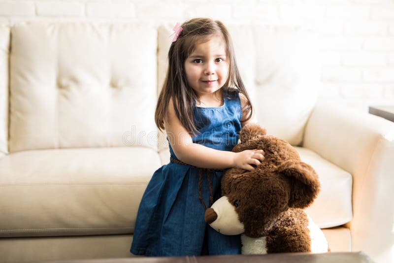 Niña que juega con el oso de peluche en casa foto de archivo libre de regalías Niña que juega con el oso de peluche en casa foto de archivo libre de regalías