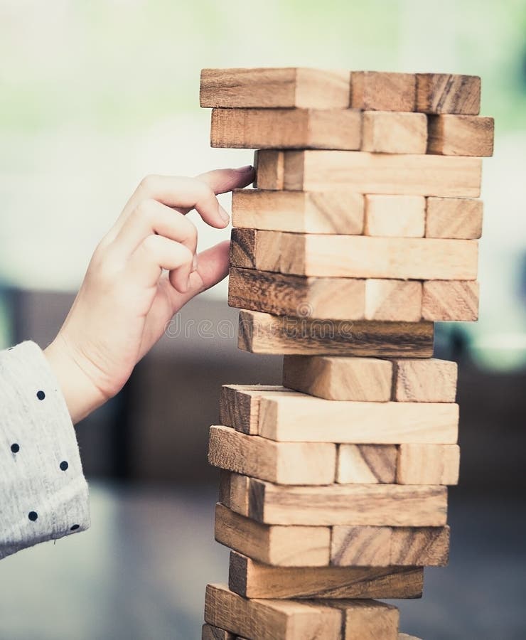 Niña que juega construyendo una torre de madera del bloque del juguete imagen de archivo libre de regalías Niña que juega construyendo una torre de madera del bloque del juguete imagen de archivo libre de regalías
