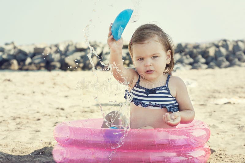 Niña que juega en la playa, cerca del mar imagen de archivo Niña que juega en la playa, cerca del mar imagen de archivo