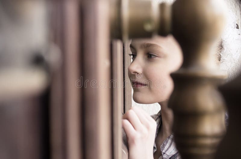 Niña que mira la ventana de la puerta del tiro fotos de archivo Niña que mira la ventana de la puerta del tiro fotos de archivo