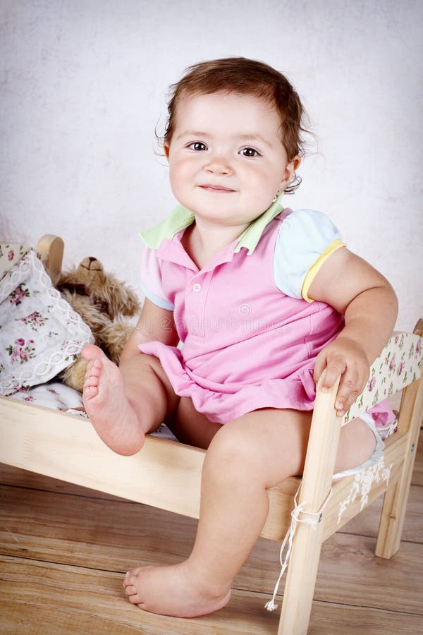 Niña que se divierte en pequeña cama imagenes de archivo Niña que se divierte en pequeña cama imagenes de archivo