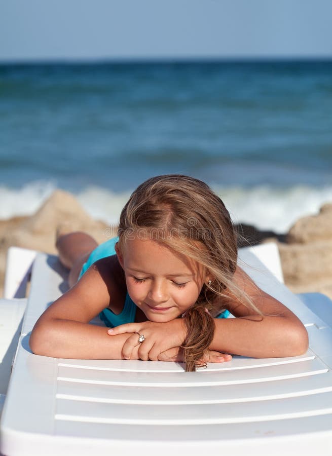 Niña que se relaja en una silla de playa fotos de archivo