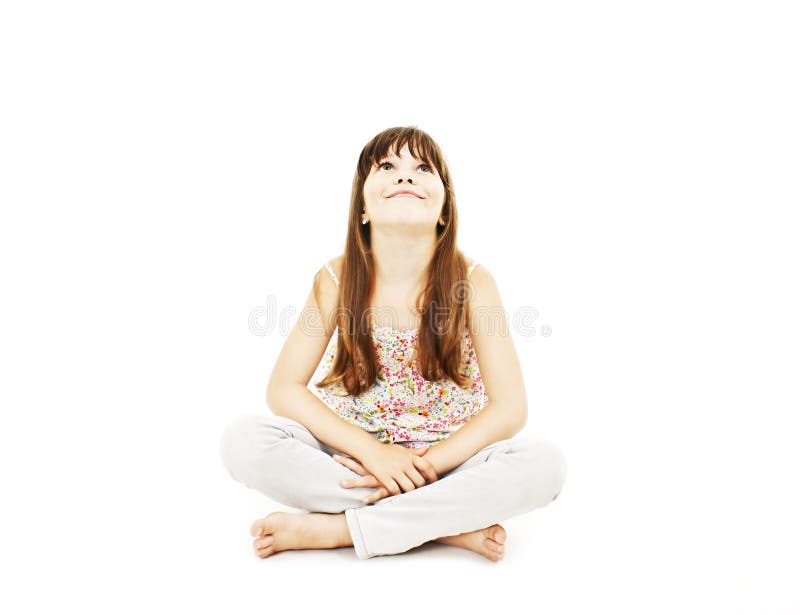 Little girl sitting on the floor, smiling and looking up. Isolated on white background. Little girl sitting on the floor, smiling and looking up. Isolated on white background