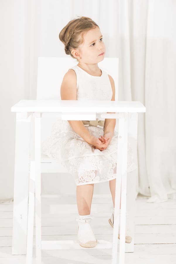 Niña que se sienta solamente en el café blanco de la tabla imágenes de archivo libres de regalías Niña que se sienta solamente en el café blanco de la tabla imágenes de archivo libres de regalías