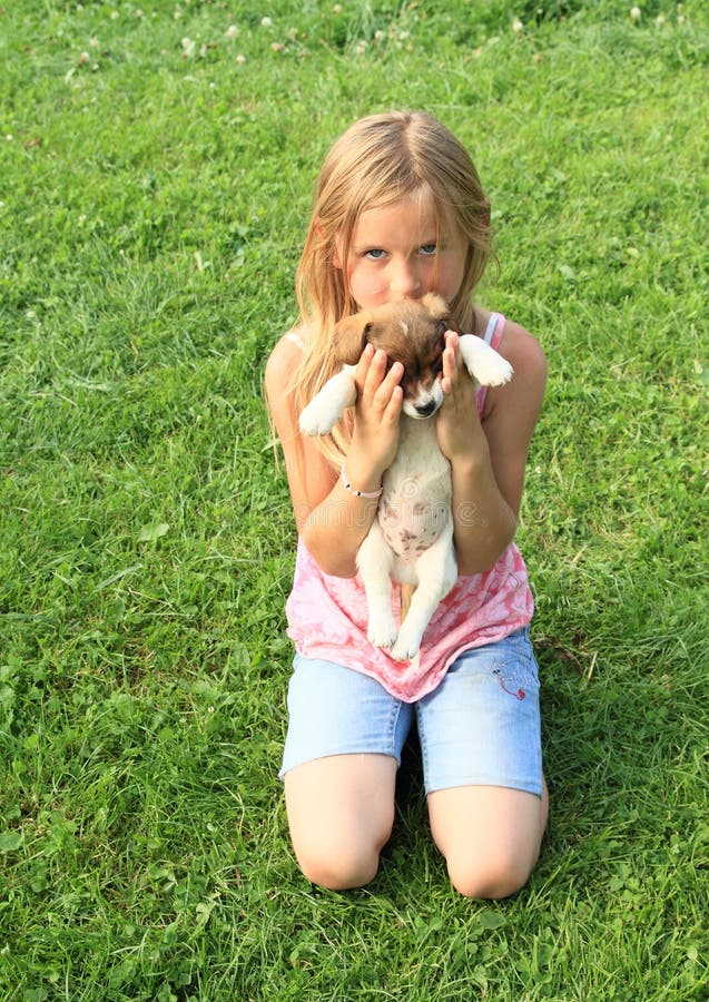 Niña que sostiene un perrito fotos de archivo Niña que sostiene un perrito fotos de archivo
