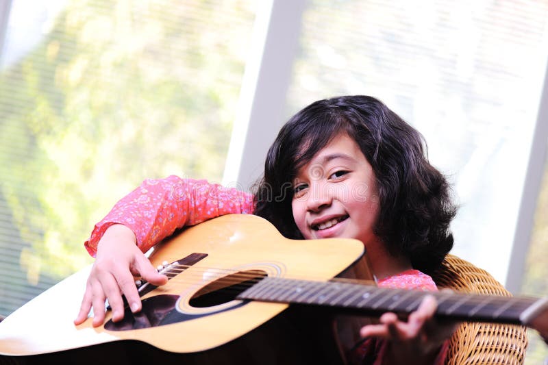 Niña que toca la guitarra fotografía de archivo libre de regalías Niña que toca la guitarra fotografía de archivo libre de regalías