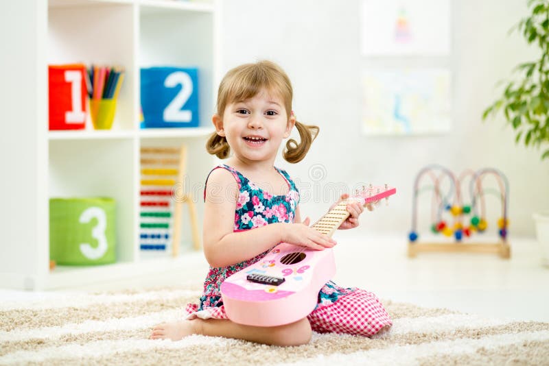 Niña que toca la guitarra foto de archivo Niña que toca la guitarra foto de archivo