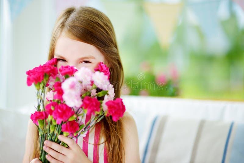 Adorable smiling little girl holding flowers for her mom. Adorable smiling little girl holding flowers for her mom