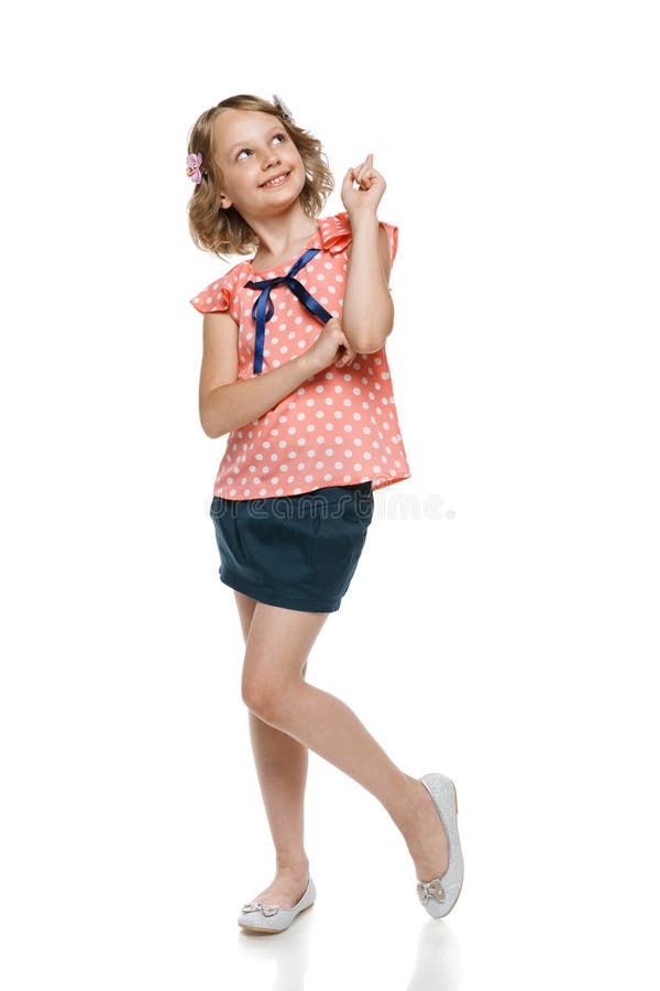 Full length of smiling little girl pointing and looking up, over white. Full length of smiling little girl pointing and looking up, over white