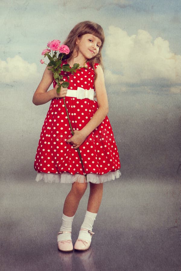 Niña sonriente que sostiene las flores fotos de archivo Niña sonriente que sostiene las flores fotos de archivo