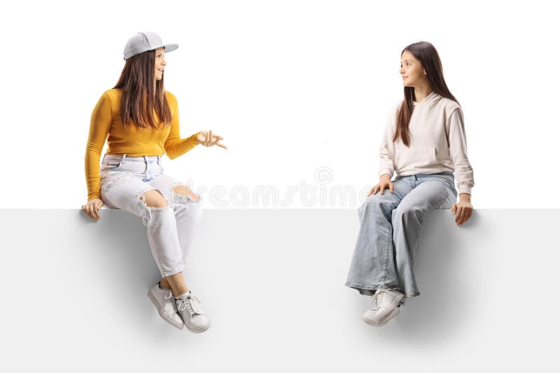 Niñas adolescentes sentadas en un panel y hablando foto de archivo